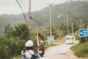 pexels photo 1879305 1879305 Motorcyclists travel a scenic rural road amidst lush greenery and distant hills.